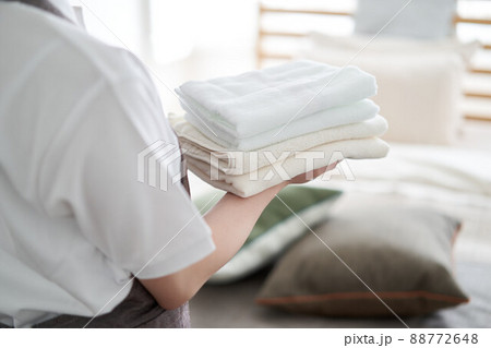 タオルを畳んで片付けるアジア人女性 タオルを畳んで片付けるアジア人女性 88772648