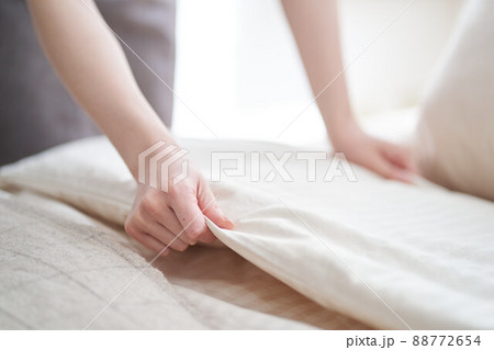 寝室でベッドメイキングをするアジア人女性	 88772654