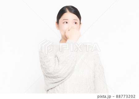 悪臭に困って鼻をつまんでいる女性 88773202