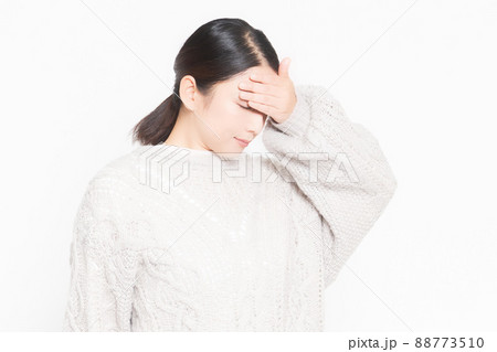 体調不良で頭に手を当てる女性 88773510
