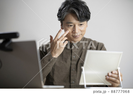 鏡に向かってBBクリームを塗るミドルの男性　メンズメイク　イメージ 88777068