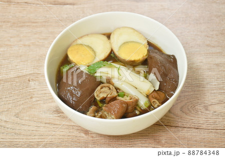 Chinese rice flour paste with pork and entrails topping egg yolk in soup on bowl Chinese rice flour paste with pork and entrails topping egg yolk in soup on bowl 88784348