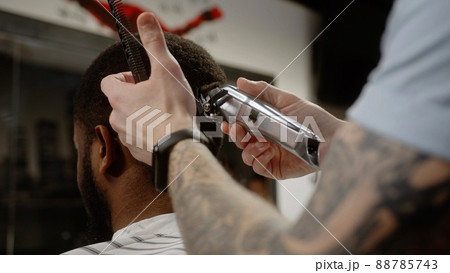 The trimmer cuts the curled hair of an African American - macro shot 88785743