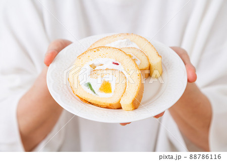 ロールケーキを持つミドル女性 88786116