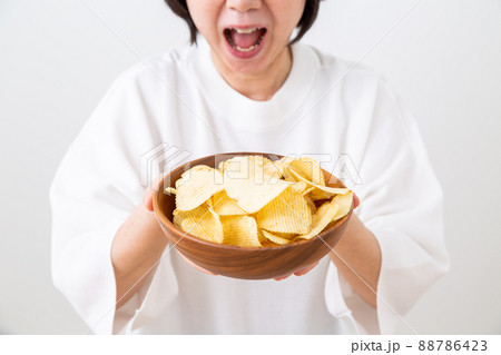 ポテトチップスを持つミドル女性 ポテトチップスを持つミドル女性 88786423