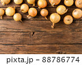 Overhead shot of fresh onions on rustic wooden table with copyspace 88786774