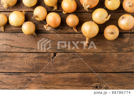 Overhead shot of fresh onions on rustic wooden table with copyspace Overhead shot of fresh onions on rustic wooden table with copyspace 88786774