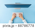 Overhead shot of woman hands working on computer on blue background. Office desktop. Flat lay 88786778