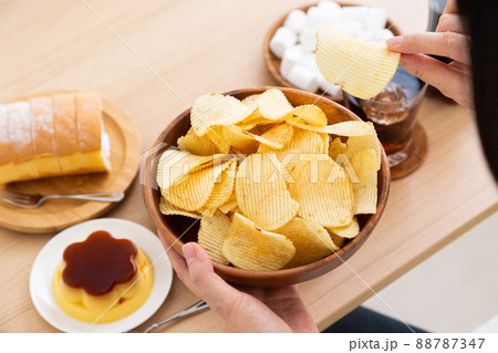 ポテトチップスを食べるミドル女性 88787347