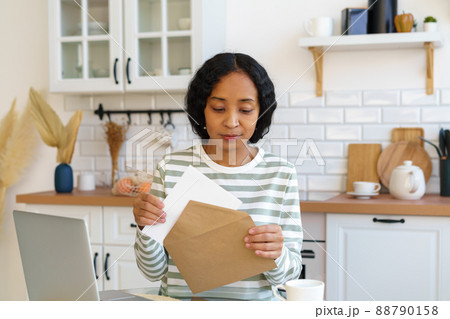 African-american female sending letter. Preparing correspondence for mail delivery. Closing envelope African-american female sending letter. Preparing correspondence for mail delivery. Closing envelope 88790158