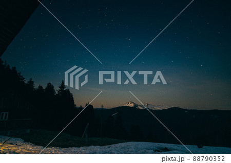 Snowy meadow, snowy mountains and stars in the background Snowy meadow, snowy mountains and stars in the background 88790352
