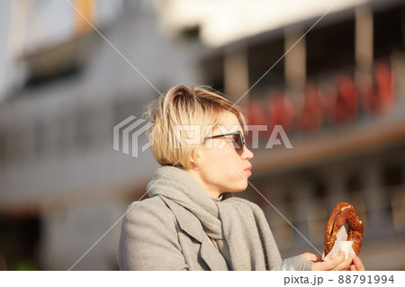 Young woman eating turkish bagel in Istanbul, Turkey. Traditional turkish street food. Young woman eating turkish bagel in Istanbul, Turkey. Traditional turkish street food. 88791994