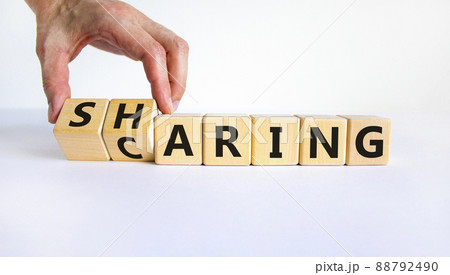 Sharing is caring symbol. Businessman turns wooden cubes and changes the word 'sharing' to 'caring'. Beautiful white table, white background. Business, sharing is caring concept. Copy space. 88792490