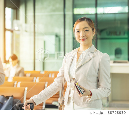 At the airport check-in counter, a passenger hands over his documents to the manager via a counter ticket. At the airport check-in counter, a passenger hands over his documents to the manager via a counter ticket. 88798030