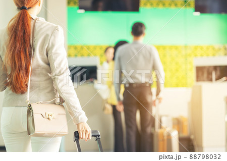 At the airport check-in counter, a passenger hands over his documents to the manager via a counter ticket. At the airport check-in counter, a passenger hands over his documents to the manager via a counter ticket. 88798032