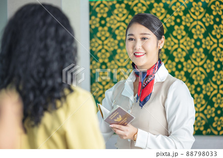 At the airport check-in counter, a passenger hands over his documents to the manager via a counter ticket. 88798033