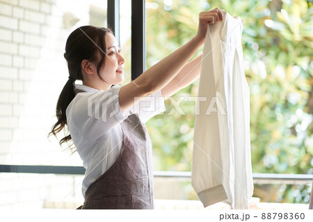 窓際で洗濯物を干すアジア人女性 窓際で洗濯物を干すアジア人女性 88798360