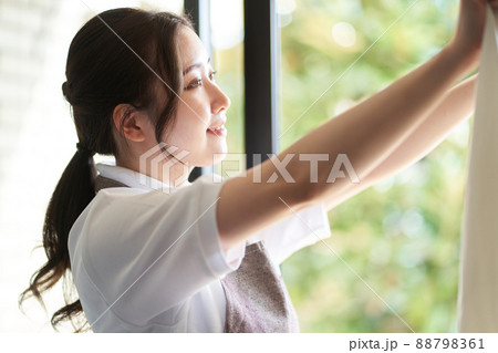 窓際で洗濯物を干すアジア人女性 窓際で洗濯物を干すアジア人女性 88798361