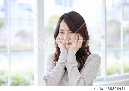 歯が痛くて頬を押さえる女性 88806951