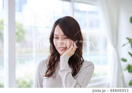 歯が痛くて頬を押さえる女性 88806953