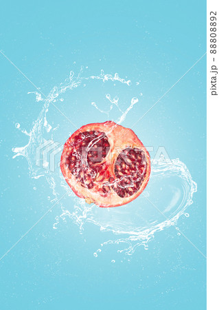 Pomegranate slice with water splash isolated on blue blackground. 88808892