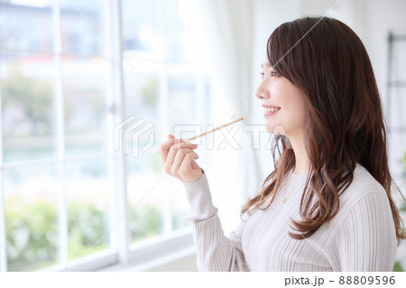 スマホを見ながら歯磨きをする女性 88809596