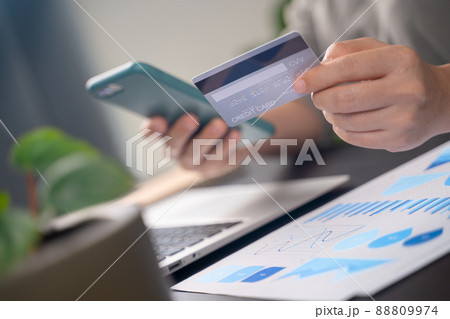 Close up shot of females hands holding credit card typing message on smart phone for shopping online Close up shot of females hands holding credit card typing message on smart phone for shopping online 88809974