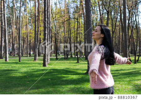 Woman walking in a park, smiling and enjoying fresh air. 88810367
