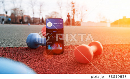 Fitness app. Smart phone screen with fitness health or sport gym mobile application on dumbbell background. App for training indoors. 88810633