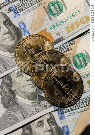 Bitcoin on banknotes of one hundred dollars. Exchange US dollars for bitcoin. Cryptocurrency on dollar bills. Digital modern method of payment. Concep of virtual money. Bitcoin on banknotes of one hundred dollars. Exchange US dollars for bitcoin. Cryptocurrency on dollar bills. Digital modern method of payment. Concep of virtual money. 88812314