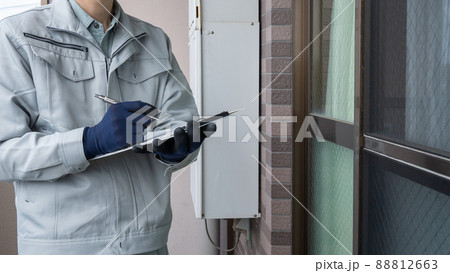 マンションの外壁、窓、網戸、給湯器を点検する作業員｜調査・見積りイメージ 88812663
