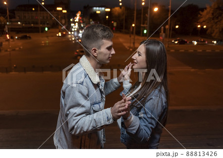 Guy gently hugs and dancing with his girlfriend on evening city background 88813426