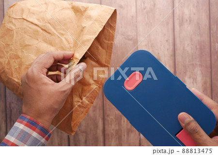 putting a lunch box in a lunch paper packet putting a lunch box in a lunch paper packet 88813475