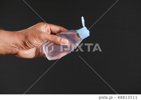 young man pouring hair oil on against black background  88813511