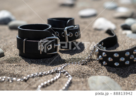 leather handcuffs for bdsm sex toys on a sandy beach leather handcuffs for bdsm sex toys on a sandy beach 88813942