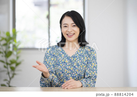 カメラ目線で話す笑顔のミドル女性 88814204
