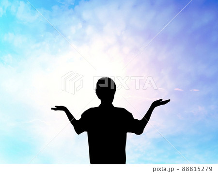 両手を上に向けて立つ男性シルエット_スピリチュアルな空背景 88815279