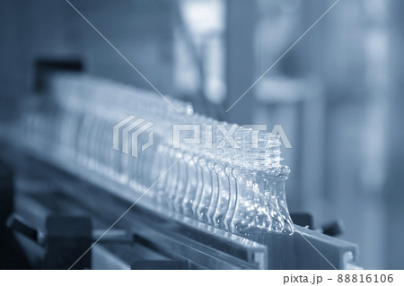 The empty PET bottles on the conveyor belt for filling process in the drinking water factory. The empty PET bottles on the conveyor belt for filling process in the drinking water factory. 88816106