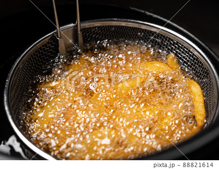 Cooking potatoes wedges in deep fryer Cooking potatoes wedges in deep fryer 88821614