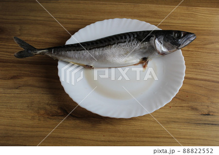 mackerel fish is lying on a white plate on the table. Home cooking meals 88822552