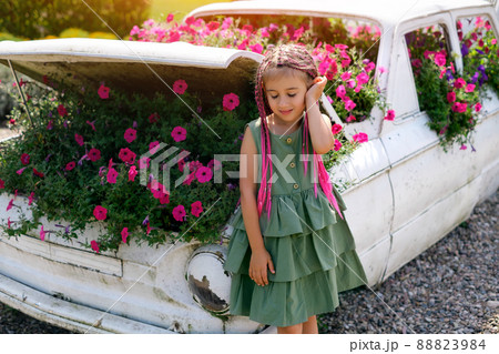 A girl with fashionable zizi pigtails from kanekalon closed her eyes from enjoying the smell of flowers. A kid is standing by a decorative car used instead of a flowerbed. Landscape Design Ideas A girl with fashionable zizi pigtails from kanekalon closed her eyes from enjoying the smell of flowers. A kid is standing by a decorative car used instead of a flowerbed. Landscape Design Ideas 88823984