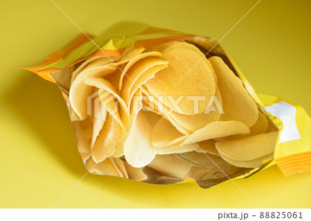 Potato chips on yellow background, Potato chips is snack in bag package wrapped in plastic ready to eat and fat food or junk food Potato chips on yellow background, Potato chips is snack in bag package wrapped in plastic ready to eat and fat food or junk food 88825061