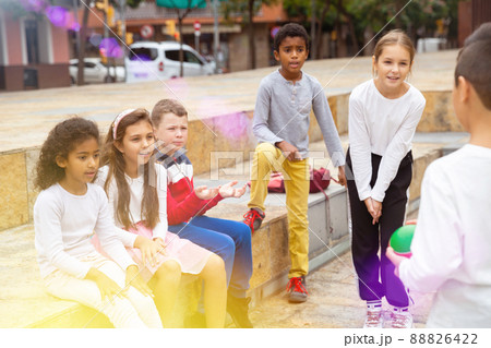 Children during conversation sitting on stairs outdoors 88826422