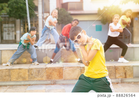 Tween boy hip hop dancer performing with group on city street 88826564