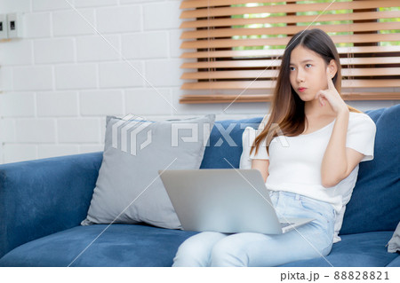 Young asian woman work on laptop computer on sofa at home with frustrated and bored. 88828821