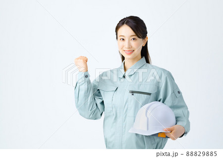 ガッツポーズをしながらヘルメットを持つ若い作業員の女性 88829885