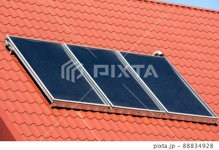 Water solar collector on a red metal roof Water solar collector on a red metal roof 88834928