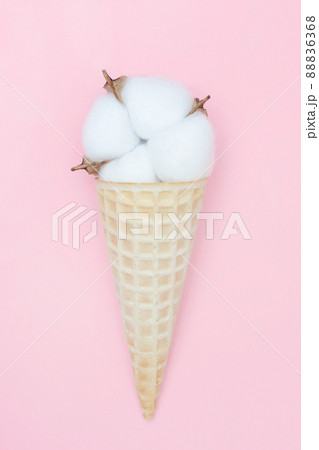 Cotton flower in an ice cream waffle cone. The concept of softness, beauty and taste. Pink background. Blog about life and style. Vertical. Flat lay. Top view. 88836368