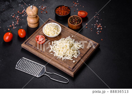 Image of a bar and grated mozzarella cheese on a dark background 88836513