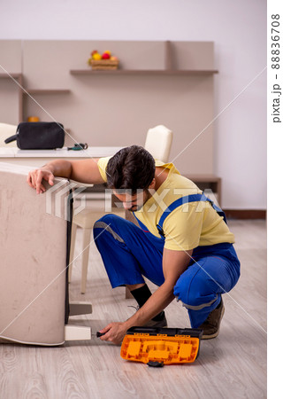 Young male carpenter repairing arm-chair at home Young male carpenter repairing arm-chair at home 88836708